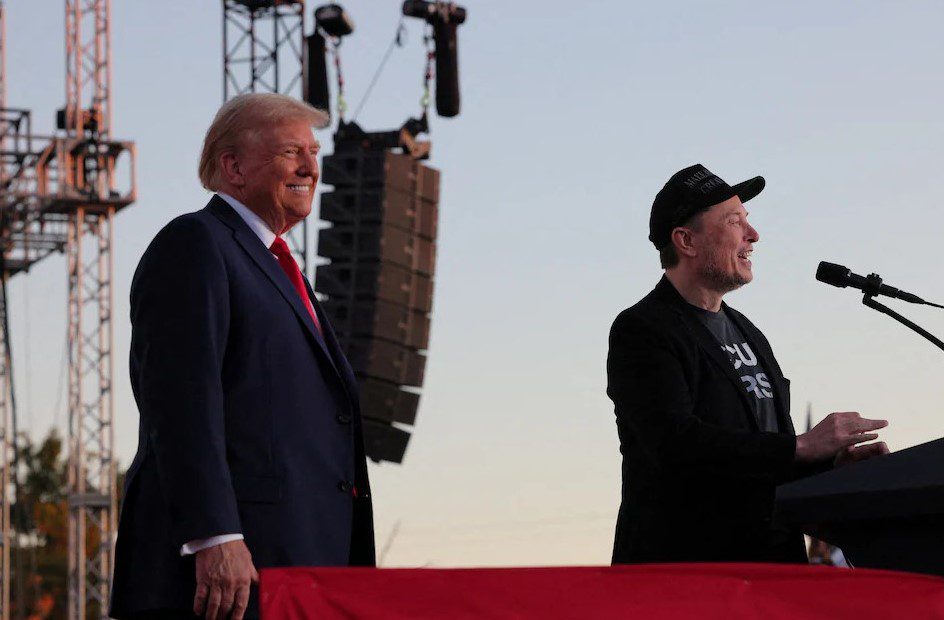 Tesla CEO and X owner Elon Musk speaks as Donald Trump looks on during a rally at the site of the July assassination attempt against Trump, in Butler, Pennsylvania, U.S., October 5, 2024. REUTERS/Brian Snyder/File Photo