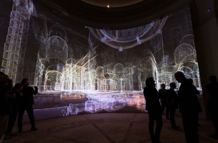 Visitors look at AI-generated images of corridors and rooms inside St. Peter's Basilica as the Vatican presents a new AI-enhanced experience developed in collaboration with Microsoft for tourists visiting the Basilica at the Vatican, November 9, 2024. REUTERS/Remo Casilli/File Photo